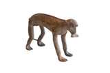 Vintage handmade African monkey sculpture with a banana, featuring a rustic and textured patina.