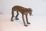 Profile view of the vintage African monkey's handmade form and aged patina.
