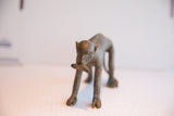 Handmade vintage African monkey figurine with a banana, shown from the front.