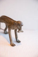 Profile view of the vintage monkey figurine highlighting its rustic handmade texture.