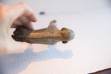 Overhead view of the vintage monkey figurine showing its carved spine and weathered texture.