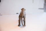 Textured spine and curled tail on the back of a vintage African monkey figurine.