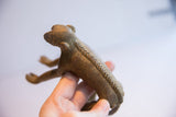 Side view of the vintage monkey figurine highlighting its textured spine and aged patina.