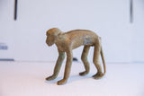 Vintage African monkey figurine showing its aged bronze patina and textured back.