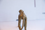 Rear view of the handmade vintage monkey figurine showing its textured spine.