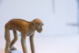 Aged patina and handmade details on the face of a collectible monkey figurine.