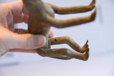The textured underside of the handmade African monkey figure showing its vintage character.