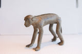 Vintage African monkey figurine showing its elongated form and textured spine.