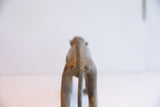 Rear view of the vintage African monkey sculpture showing its textured, braided spine.