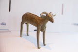 Side profile of the vintage African ram sculpture with a weathered patina.