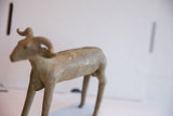 Soft-focus profile of the vintage African ram sculpture, highlighting its form and patina.