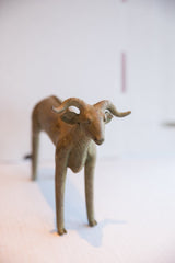 The face and prominent, textured horns of the handmade African ram sculpture.