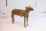 Angled view of the vintage African ram sculpture, showing its handcrafted texture and form.