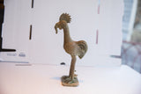 African rooster sculpture's textured head, ridged neck, and unique beak with worm.