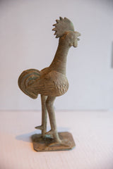 Textured body and ribbed neck of the vintage African rooster sculpture with patina.