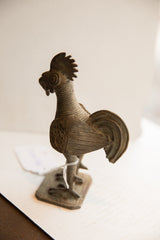 Side profile view of the vintage African rooster sculpture highlighting its textured body and form.