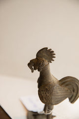 Profile view of the vintage rooster's head showing its carved comb, eye, and textured neck.