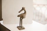 Vintage African bird sculpture in profile, highlighting its crowned head and handmade texture.