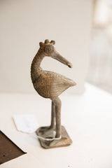 Side view of the vintage African bird sculpture showing its textured body and crowned head.