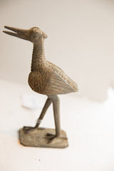 Side profile of the vintage African bird sculpture, highlighting its handmade texture and patina.