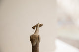 The rustic, weathered texture of the handmade African bird sculpture's head.
