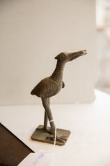 Profile view of the vintage African bird sculpture, highlighting its rustic, textured finish.