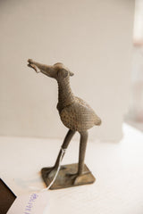 Side view of the vintage African bird sculpture showing its handmade textured details.