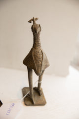 Stylized wings and textured metal body of the vintage African bird sculpture from behind.