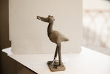 Profile view of the vintage African bird sculpture showcasing its handmade, textured patina.