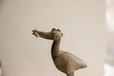 Detailed profile of the vintage bird sculpture's head, featuring a carved eye and aged texture.