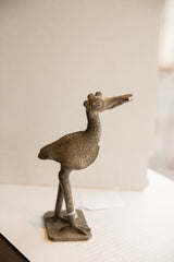 Profile view of the vintage handmade African bird sculpture showing its aged texture.