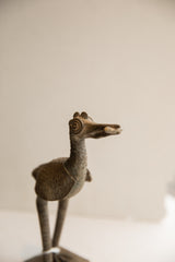 Detailed profile of the African bird sculpture's head, highlighting its handmade texture and circular eye.