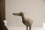 Profile view of the vintage African bird sculpture's textured head and circular eye.