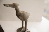 Vintage African bird sculpture's profile, detailing the textured body and spiral crest.