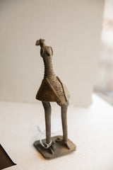 Side view of the vintage African bird sculpture, highlighting its textured surface and elongated form.