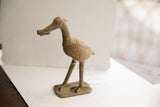 Side profile of the vintage African bird sculpture highlighting its aged patina and form.