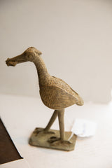 Vintage African bird sculpture with fish, seen in profile, showing its rustic, handmade character.