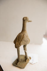 Rear view of the vintage African bird sculpture showing its textured body and stylized wings.