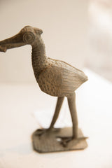 Detailed side view of the hand-carved African bird sculpture's textured body and eye.
