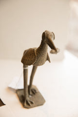 Vintage African bird sculpture with a rustic, textured surface, viewed from a high angle.