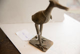 The textured legs and taloned feet of the vintage African bird sculpture.