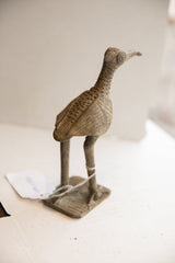 Side profile of a vintage African bird sculpture highlighting its etched texture and aged patina.