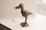 Side profile of a handmade African bird sculpture with a dark, textured patina.