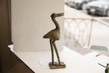Profile of a vintage African bird sculpture showing its handmade textured surface.