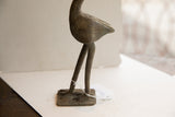 Slender legs and square base of the vintage African bird sculpture showing its handmade texture.
