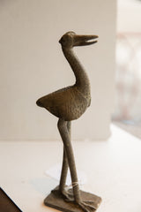 Vintage African bird sculpture in profile, showing its slender silhouette and rustic texture.