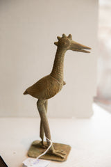 Vintage African bird sculpture in a profile view with a textured neck and weathered finish.