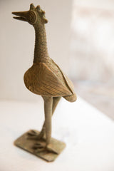 Profile of a vintage African bird sculpture showing its textured neck and carved wings.