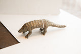 Profile of a vintage African pangolin sculpture showing its textured, hand-carved scales.