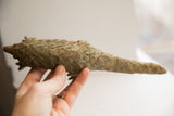 Vintage pangolin sculpture held to show the detail of its handmade, scaled body.